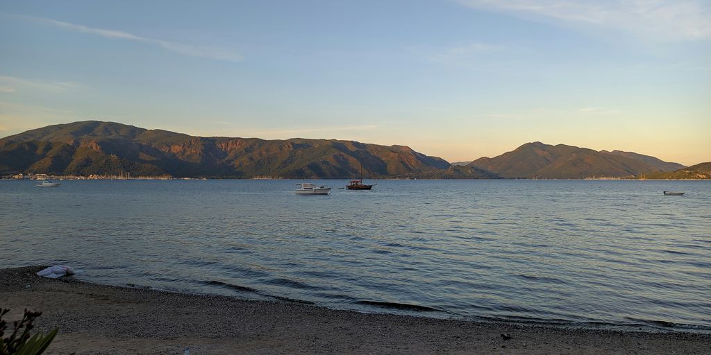 body of water near mountain under blue sky during daytime